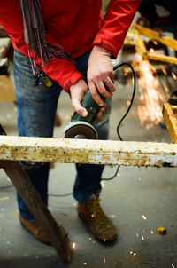 Low angle view of man grinding metal at industry