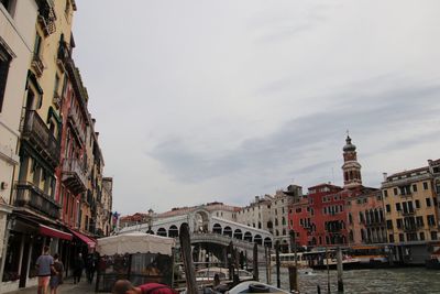 Buildings in city against cloudy sky