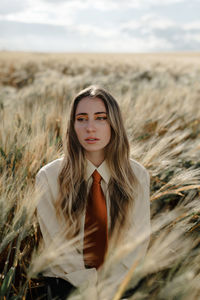 Portrait of young woman standing on field