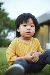 Portrait of cute girl sitting on field