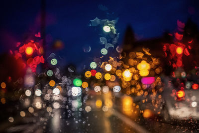 Defocused image of illuminated city street during rainy season