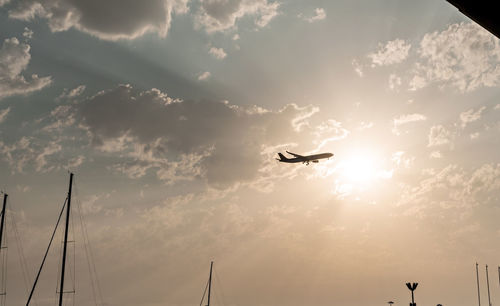 Airplane flying in sky backdrop of beautiful pink sunset among clouds natural background copy space