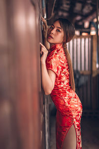 Young woman in traditional clothing against door