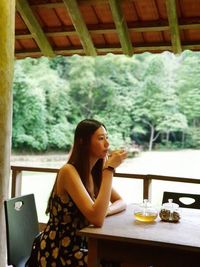 Side view of woman sitting on table