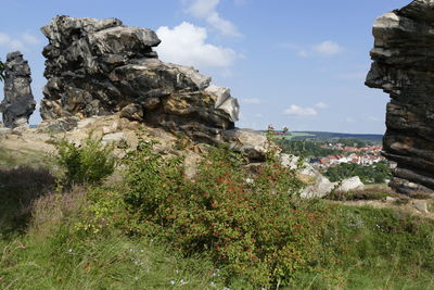 Scenic view of cliff by sea against sky