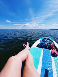 Low section of person on sea against sky