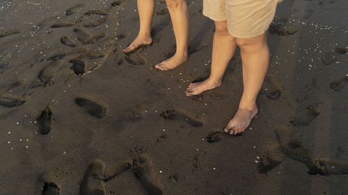 Low section of people standing on beach