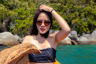 Beautiful young woman sitting on boat in sea