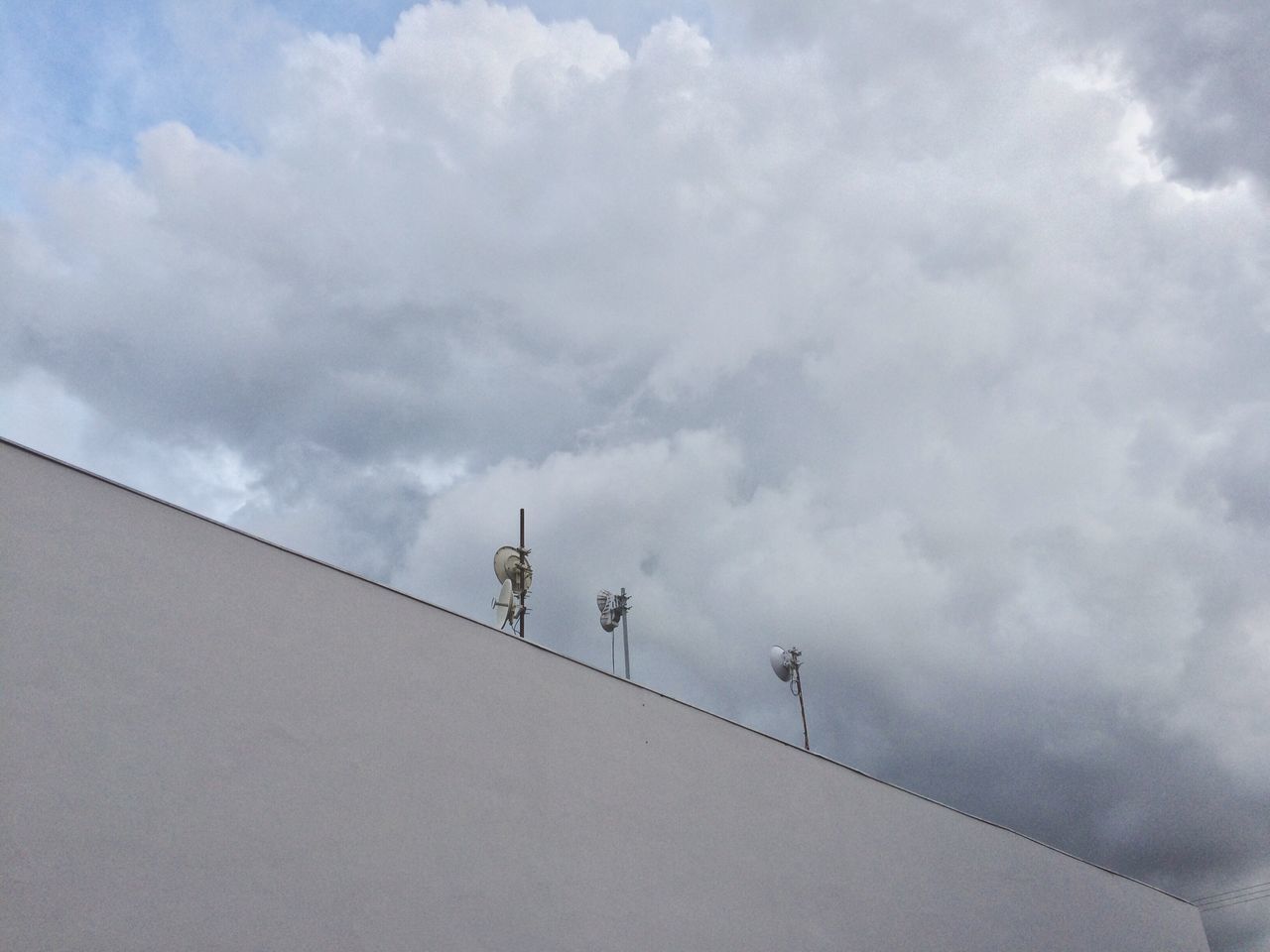 LOW ANGLE VIEW OF LIZARD ON WALL AGAINST SKY