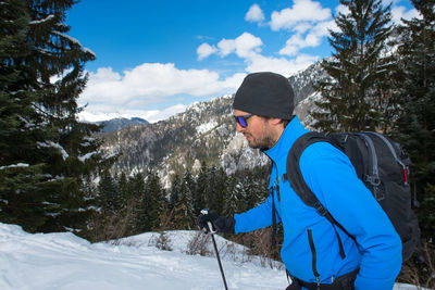 Rear view of man standing on snow covered mountain