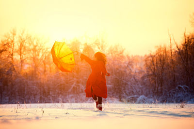 Full length of woman standing on snow covered landscape