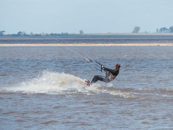 Young woman kitesurfing with beautiful waves