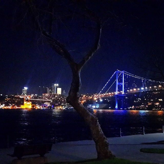 night, illuminated, water, architecture, built structure, bridge - man made structure, city, river, connection, building exterior, sky, transportation, engineering, bridge, travel destinations, waterfront, cityscape, lighting equipment, light - natural phenomenon, reflection