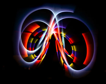 Close-up of illuminated multi colored light over black background