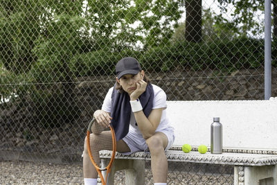 Portrait of a young professional tennis player sitting looking at the camera with sad face