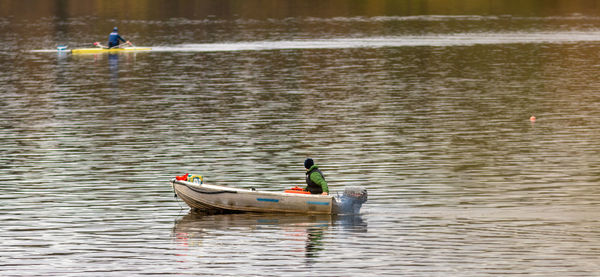 Side view of two men swimming in lake