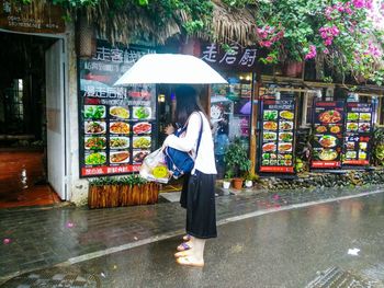 Full length of woman holding umbrella