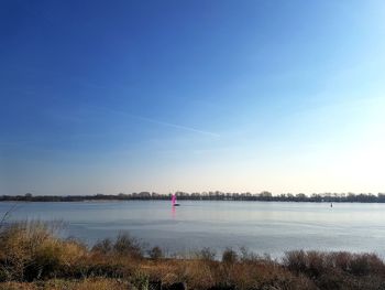 Scenic view of lake against clear blue sky