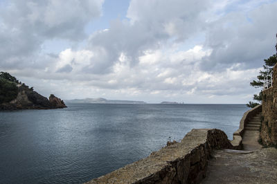 Scenic view of calm sea against cloudy sky