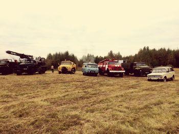 Cars on field against sky