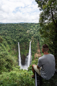 Rear view of woman looking at waterfall