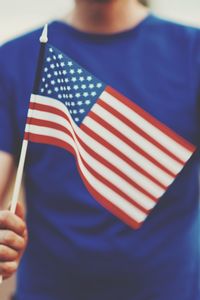 Midsection of person holding american flag