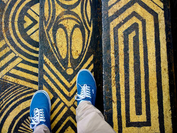 Low section of man standing on tiled floor