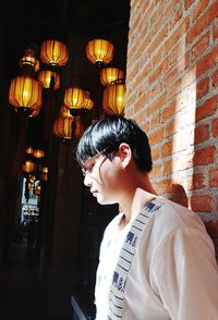 Portrait of young man looking at illuminated lamp