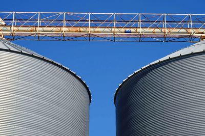 Low angle view of factory against clear blue sky