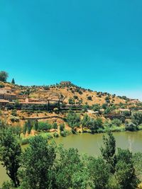 Scenic view of lake against clear blue sky