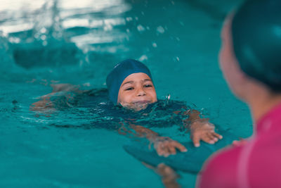 Portrait of couple swimming in pool