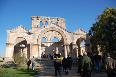 Group of people walking in front of historical building