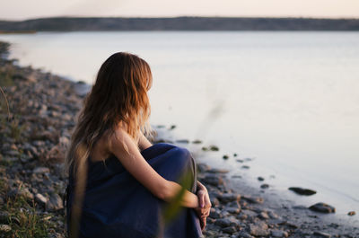 Woman sitting by lake