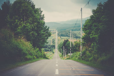 Road amidst trees against sky