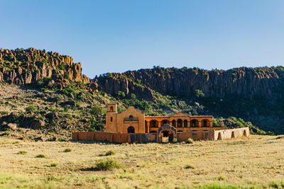 Built structure on land against clear blue sky