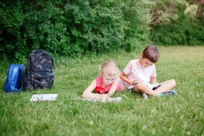 Rear view of friends sitting on grass