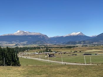 Scenic view of field and mountains against clear sky