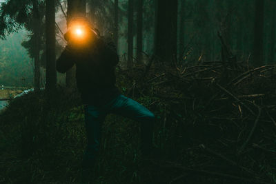Man standing in forest at night
