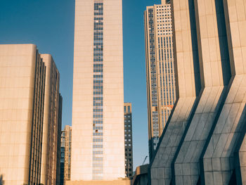 Low angle view of buildings on sunny day in city