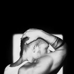 Close-up of young woman over black background