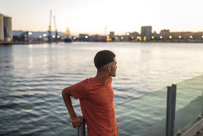 Man looking at river with city in background