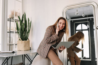 A business woman works online using a laptop phone and technology while sitting in the office