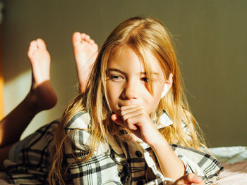 Portrait of young woman sitting on bed at home