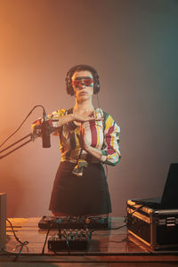 Portrait of woman playing violin while sitting on stage