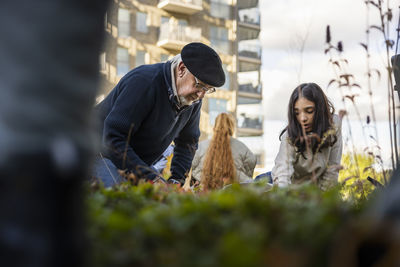 Group of neighbors gardening together in courtyard