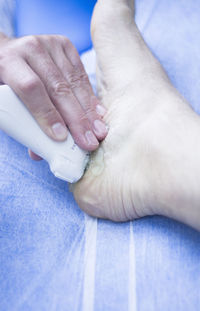 Close-up of doctor applying medicine on patient foot in hospital