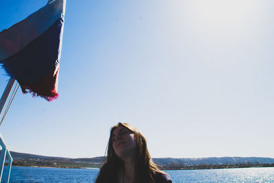 Woman looking at sea against clear sky