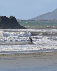 Man surfing in sea against clear sky