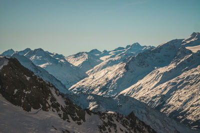 Scenic view of snowcapped mountains against clear sky