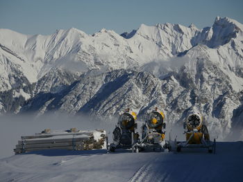 View of snow machine against snowcapped mountain 